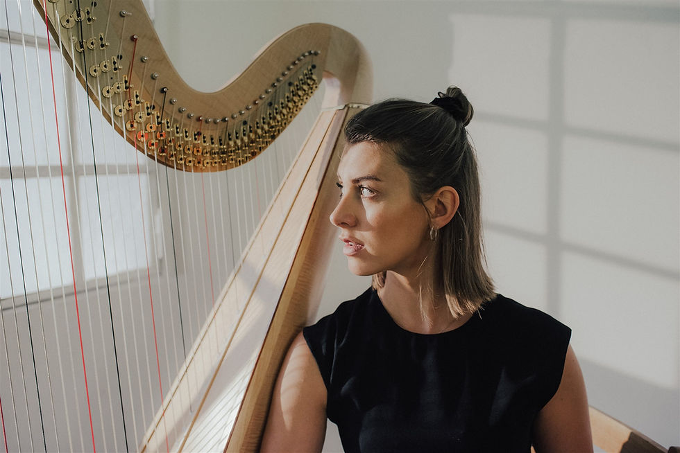Theresa Winkler im Profil neben ihrer Harfe, nachdenklicher Blick der Musikvermittlerin und Harfenistin