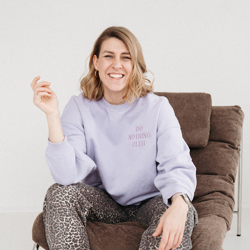 Theresa Winkler lächelnd und einladend auf einem Sofa – Kontakt aufnehmen für Musikvermittlung, Trainings und Workshops