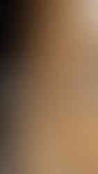 A pile of raw oak wood staves stacked against a historic red brick wall under a black industrial beam at Old Forester.