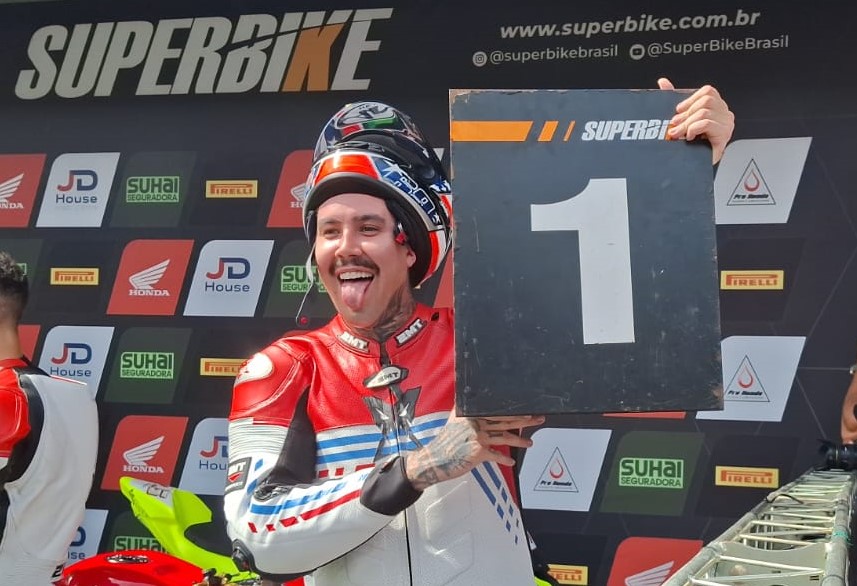 Piloto Marcos Donas segurando uma placa com o número 1