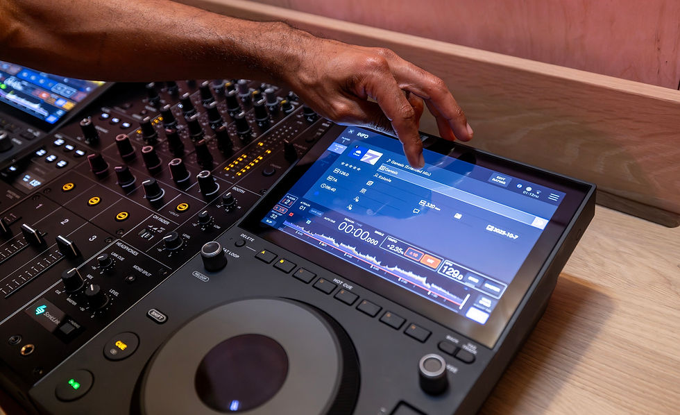 Eye-level view of a DJ selecting tracks on a touchscreen player in a dark club booth