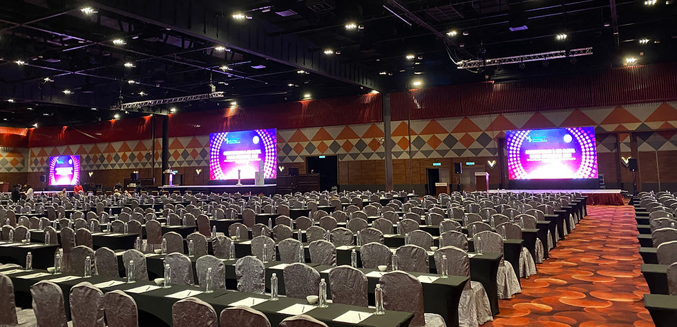 Corporate professionals attending a formal conference in a hotel grand ballroom