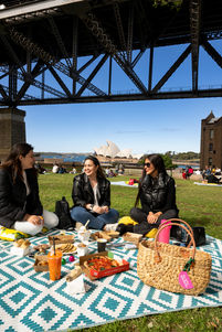 A Lifestyle photo of 3 women having a picnic under the Sydney Harbour Bridge
in The Rocks, Sydney Australia

