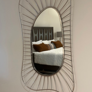 a bedroom with a bed and a mirror on the wall