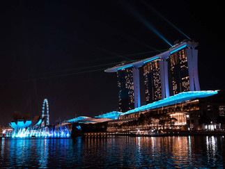 Experience the night view of Singapores Marina Bay Sands, illuminated in stunning blue and white by a professional architecture photographer. Capture the iconic three-tower hotel, serene waterfront, and Singapore Flyer, with reflections shimmering like fine art through high-end hotel photography.