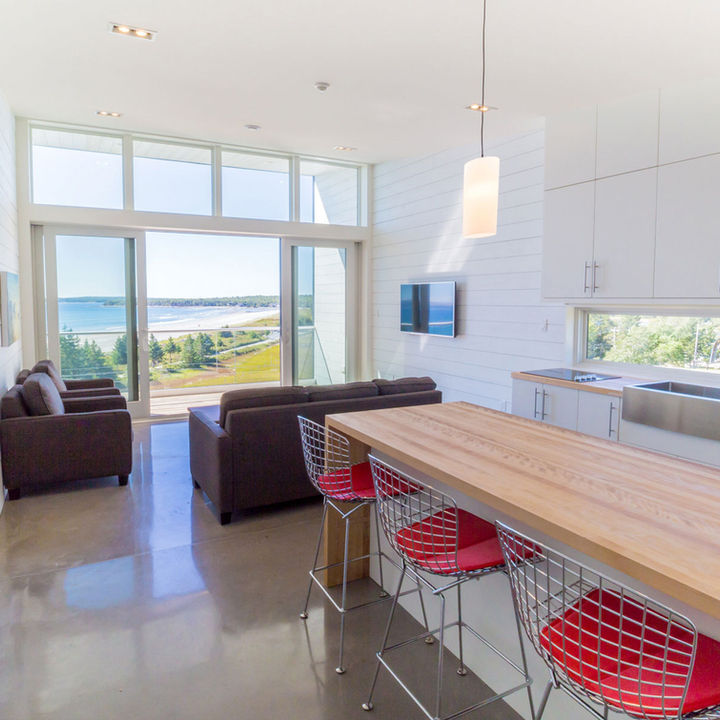 Modern architecture kitchen with white horizontal wood boards and white cabinetry in Nova Scotia designed by Nicholas Fudge Architects. 