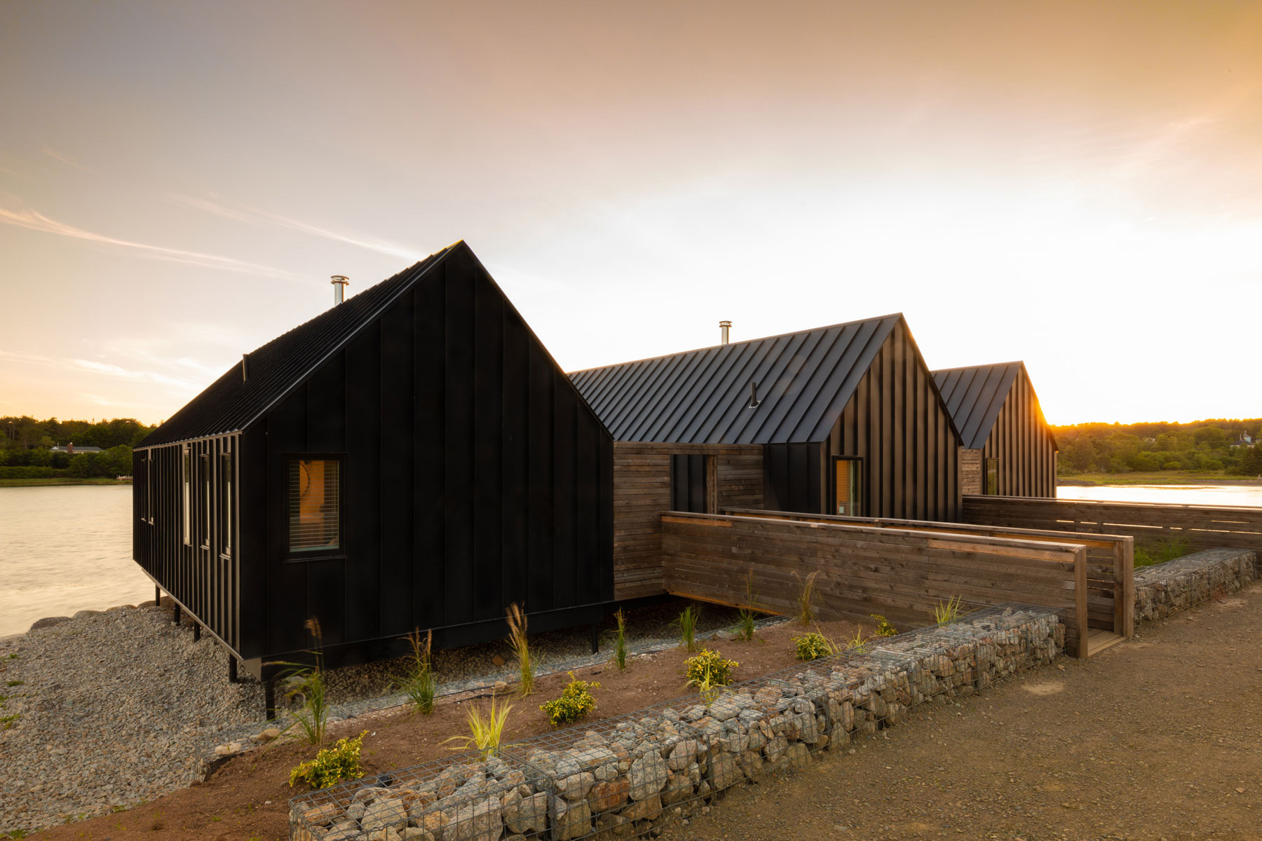 Modern architecture house with standing seam metal roof on stilts located in South Cove, Nova Scotia designed by Nicholas Fudge Architects.