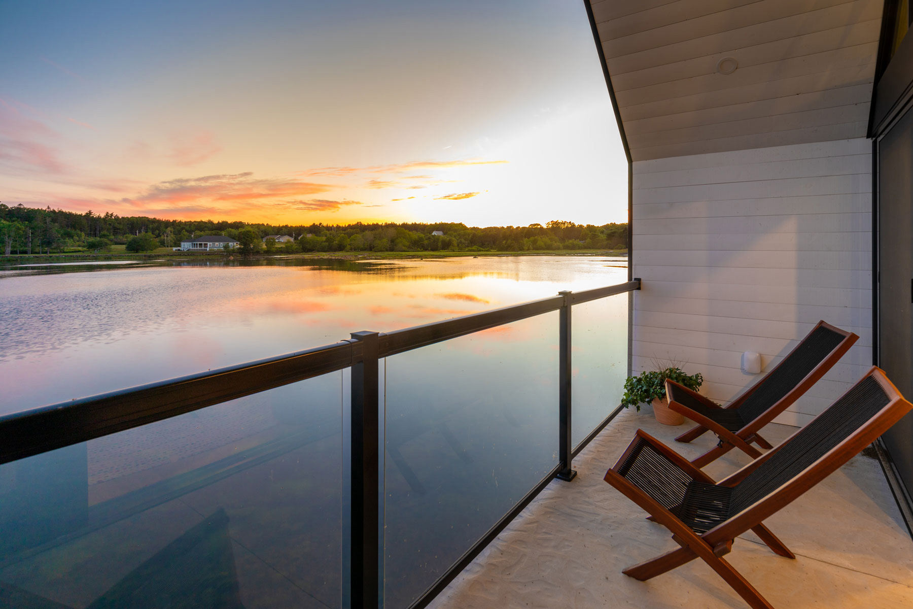 Modern architecture interior with white horizontal wood boards and metal and glass railing located in Nova Scotia designed by Nicholas Fudge Architects.