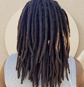 Rear view of a Black person with henna dyed dreadlocks standing outside_edited.jpg