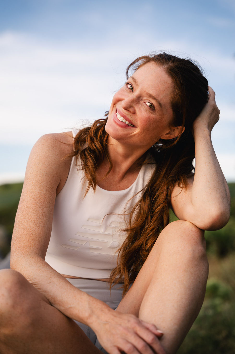 Smiling portrait of a female runner resting and looking relaxed after a workout, by a sports photographer Cape Town.