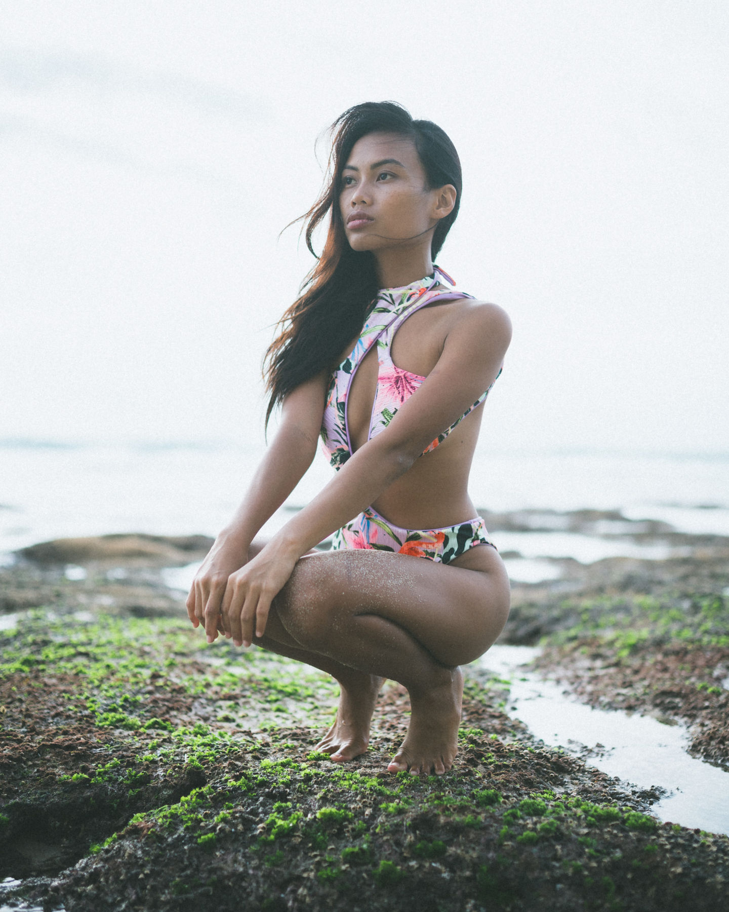 Women with a white bikini with flowers standing on the beach during sunset for a Beach photo shoot at Dreamland beach at Bali with a professional photographer from Cape Town featuring a gorgeous Model. Model Testshoot