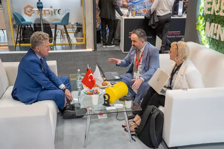 Two attendees in conversation in the FKK booth lounge area at Mining Indaba 2026