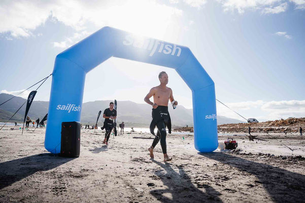 Multiple XTERRA athletes finishing race at blue branded arch during South Africa Grabouw event – event photographer
