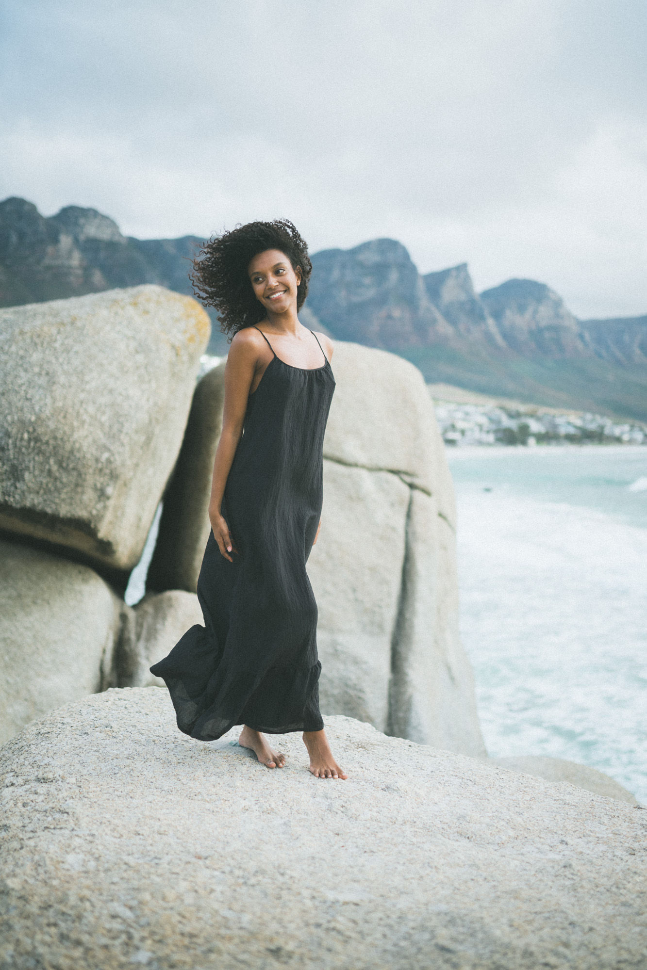 Women with a black bikini standing on the beach during sunset for a Beach photo shoot at Camps Bay beach with a professional photographer from Cape Town featuring a gorgeous Model. Model Testhoot