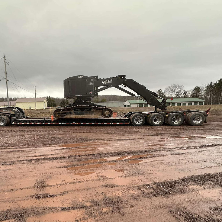 Forestry equipment being hauled on a removable gooseneck trailer.