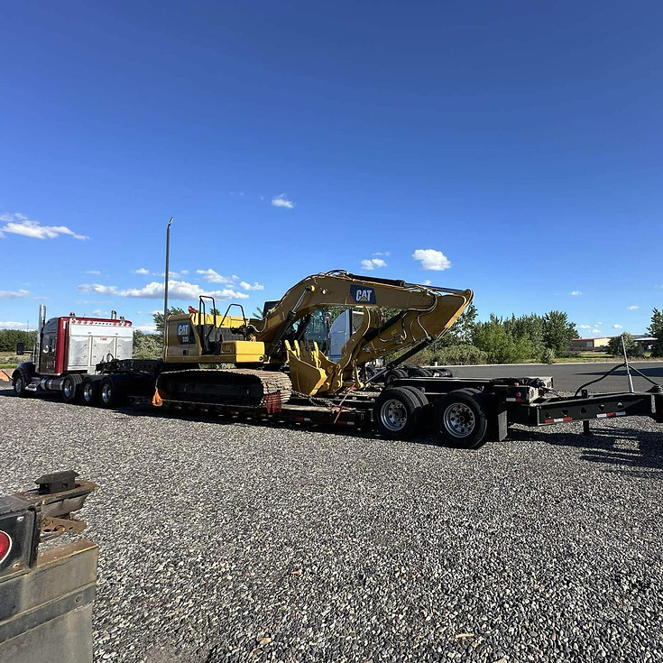 Red semi hauling an Caterpillar excavator.