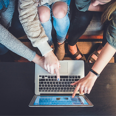 3 women pointing at a macbook
