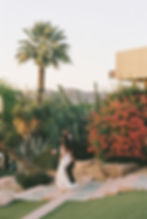 bride and groom walk down stairs at sunset candid