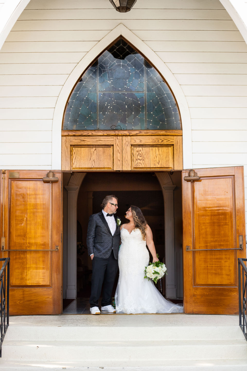 Bride and groom pose at the church doors after their ceremony, captured with editorial wedding photography Arizona and timeless wedding photos