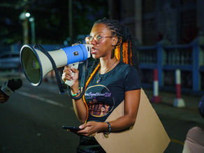 A young woman holding a megaphone speaks during  the end femicide march
