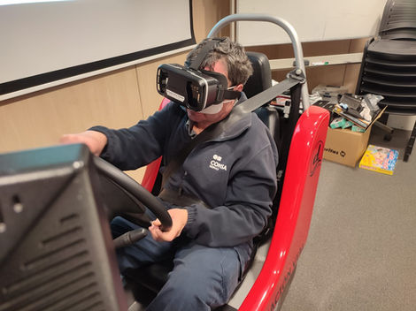 Instructor usando gafas VR en simulador de conducción