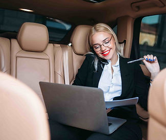 executive woman in private car working on laptop