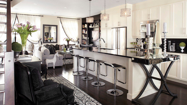 Extending the counter of the island, a mirrored glass and cross leg console turns into a space to serve meals.