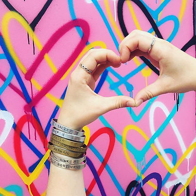 Nautical Northern handmade bracelets and rings on hands making a heart