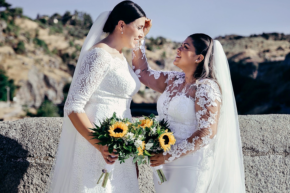 Carolina y Vanesa, novias sonrientes con ramos de girasoles