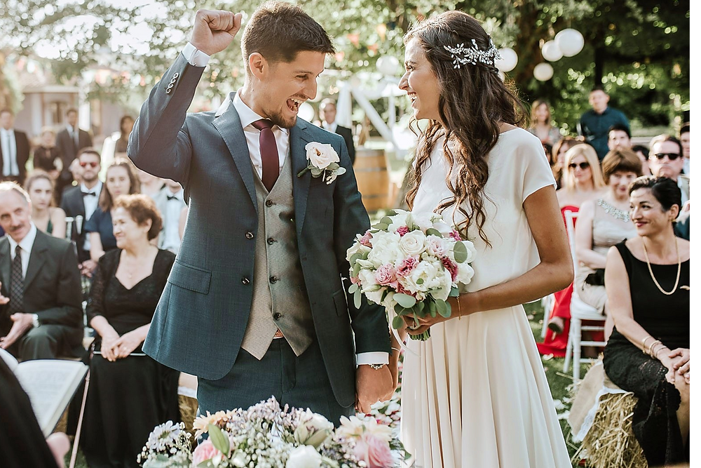 Elena y Álvaro en su boda, el novio celebra con un puño en alto.