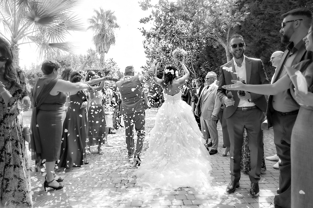 Boda en Toledo, novios bajo lluvia de pétalos y confeti.
