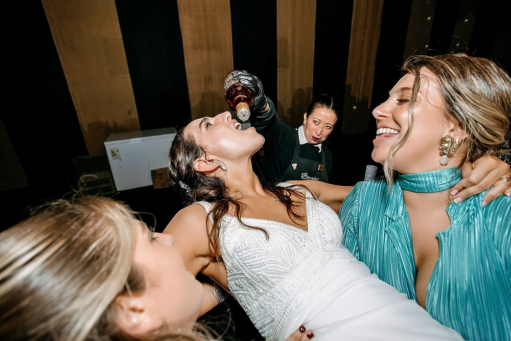 Novia Irene bebiendo de una botella en su boda.