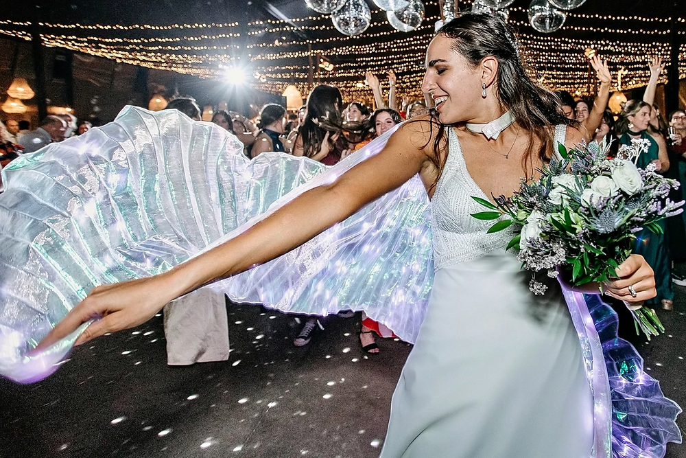 Novia Irene bailando feliz con ramo bajo luces de discoteca