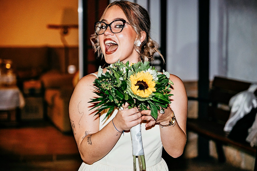 Mujer alegre con ramo de girasol en boda