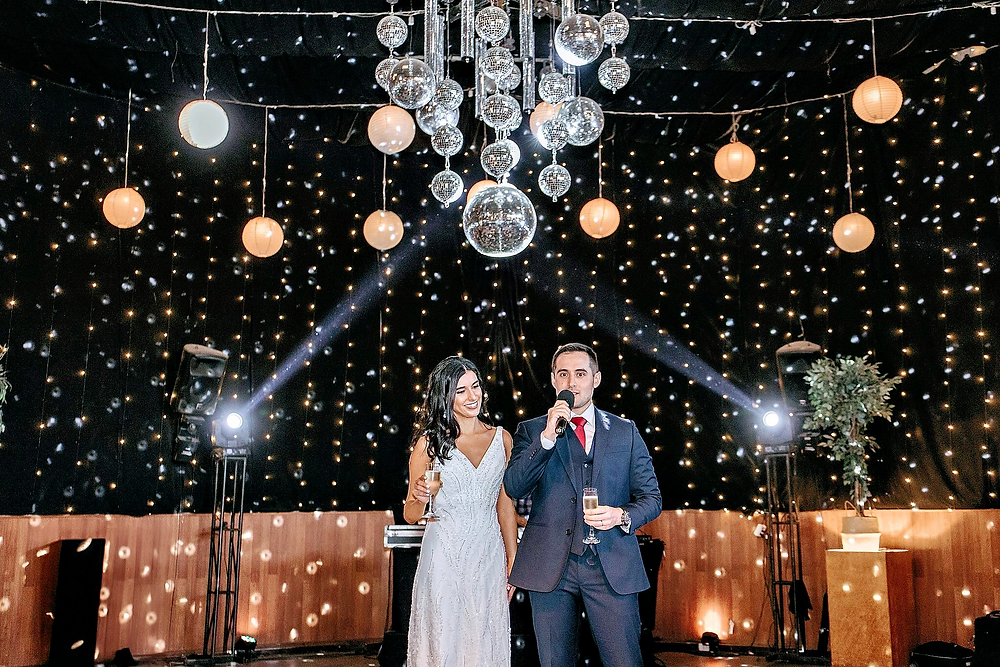Alejandro y Marina dando un discurso en su boda con luces disco