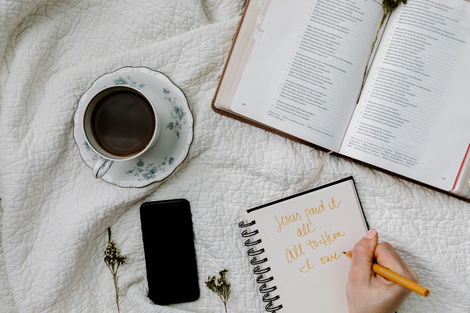 An open Bible with coffee and a notebook