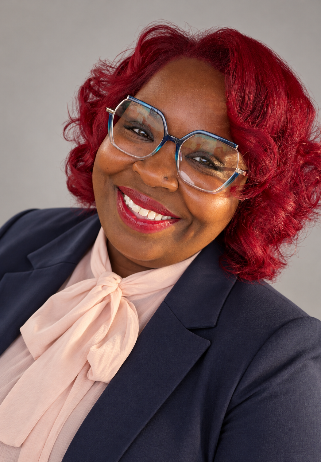 Diana Johnson in a navy blazer and pink bow blouse