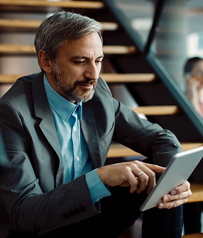 male-entrepreneur-using-digital-tablet-while-sitting-staircase.jpg