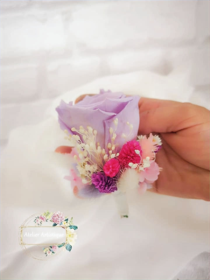 Miniatură: Mână ținând un buchet cu flori mov, roz și albe. Coroana Funerara de brad cu flori naturale.