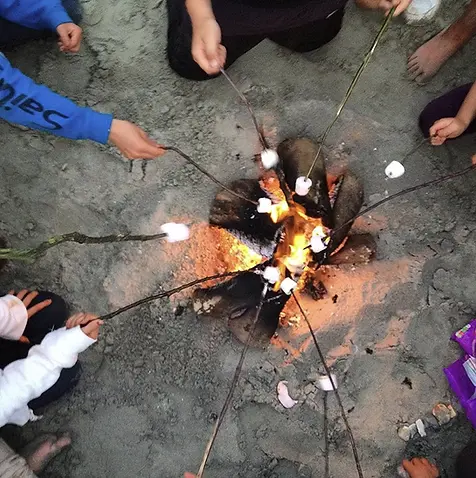 roasting marshmellows over fire at residential camp uk.webp