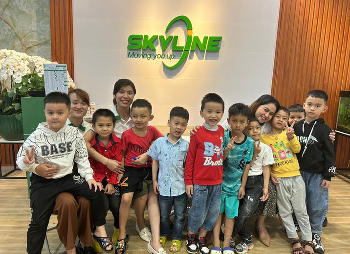 Trẻ em và giáo viên vui vẻ trước biển hiệu SKYLINE GLOBAL EDUCATION.