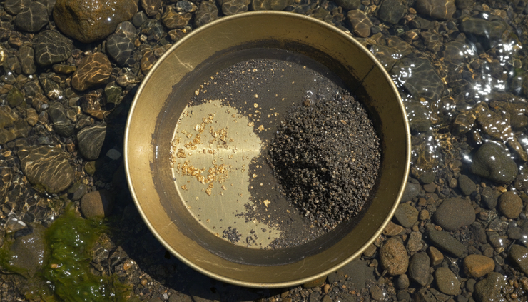 Overhead view of a gold pan with small gold flakes separated from river stones