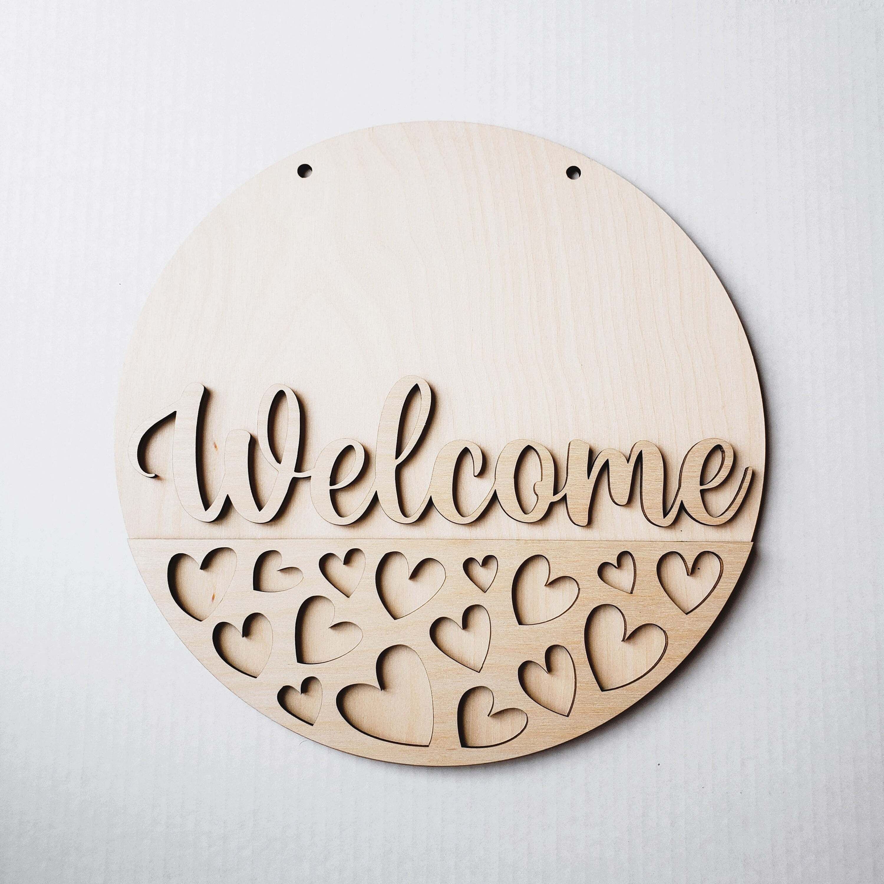 Round wooden welcome sign with hearts