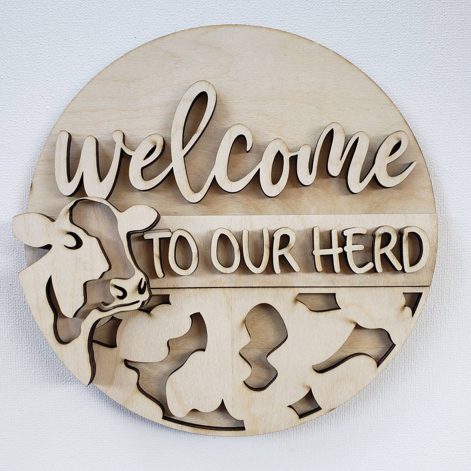 Welcome to our herd; round wood sign with cow