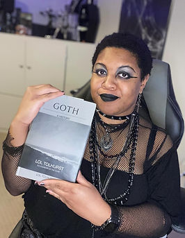 Black goth author holding Goth by Lol Tolhurst