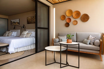 Suite Oasis en hotel boutique frente al mar con dormitorio amplio, sala acogedora, baño moderno y terraza privada con vista al océano, ideal para viajes románticos Perú.