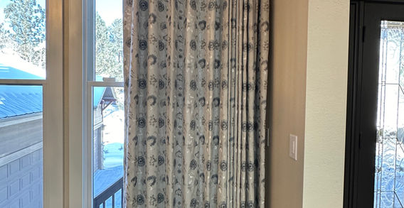 Traversing dining room draperies in blue and silver floral linen blend on custom wood rod, crafted by Rideaux Designs