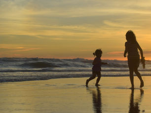 Family enjoying a beach sunset in Auckland.