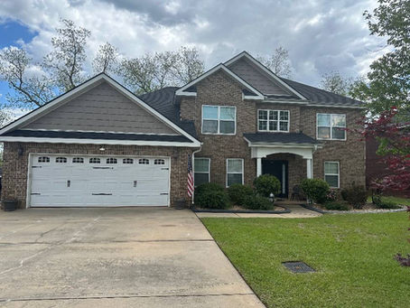 Brick home in Dallas, GA after insurance claim roof replacement by Optimum Roofing