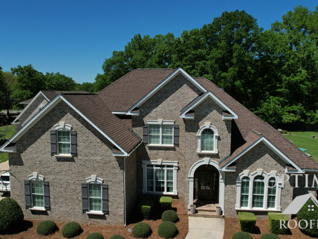 Front exterior view of a well-maintained brick home with a quality roof, representing the kind of workmanship a vetted roofing contractor should deliver in Metro Atlanta